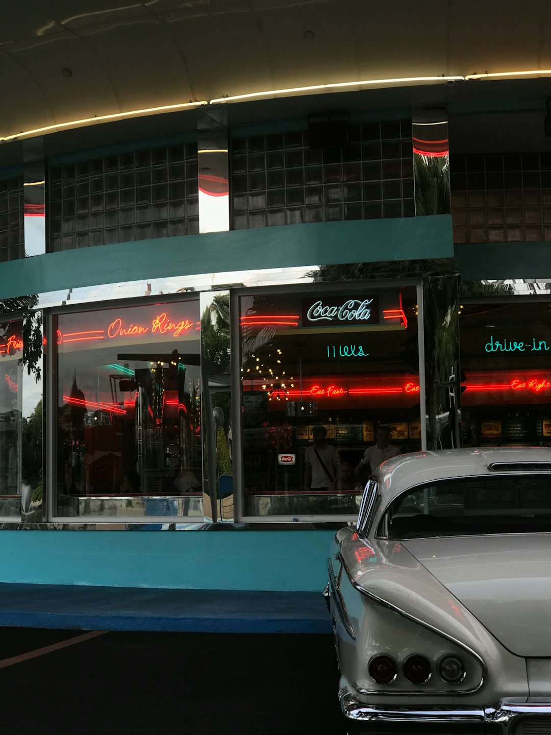 Klassischer weißer Wagen vor einem neonbeleuchteten Retro-Diner.
