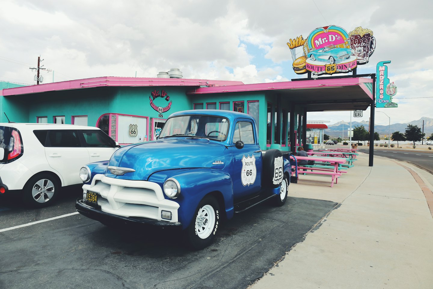 Blauer Oldtimer-Pick-up vor einem Retro-Diner.