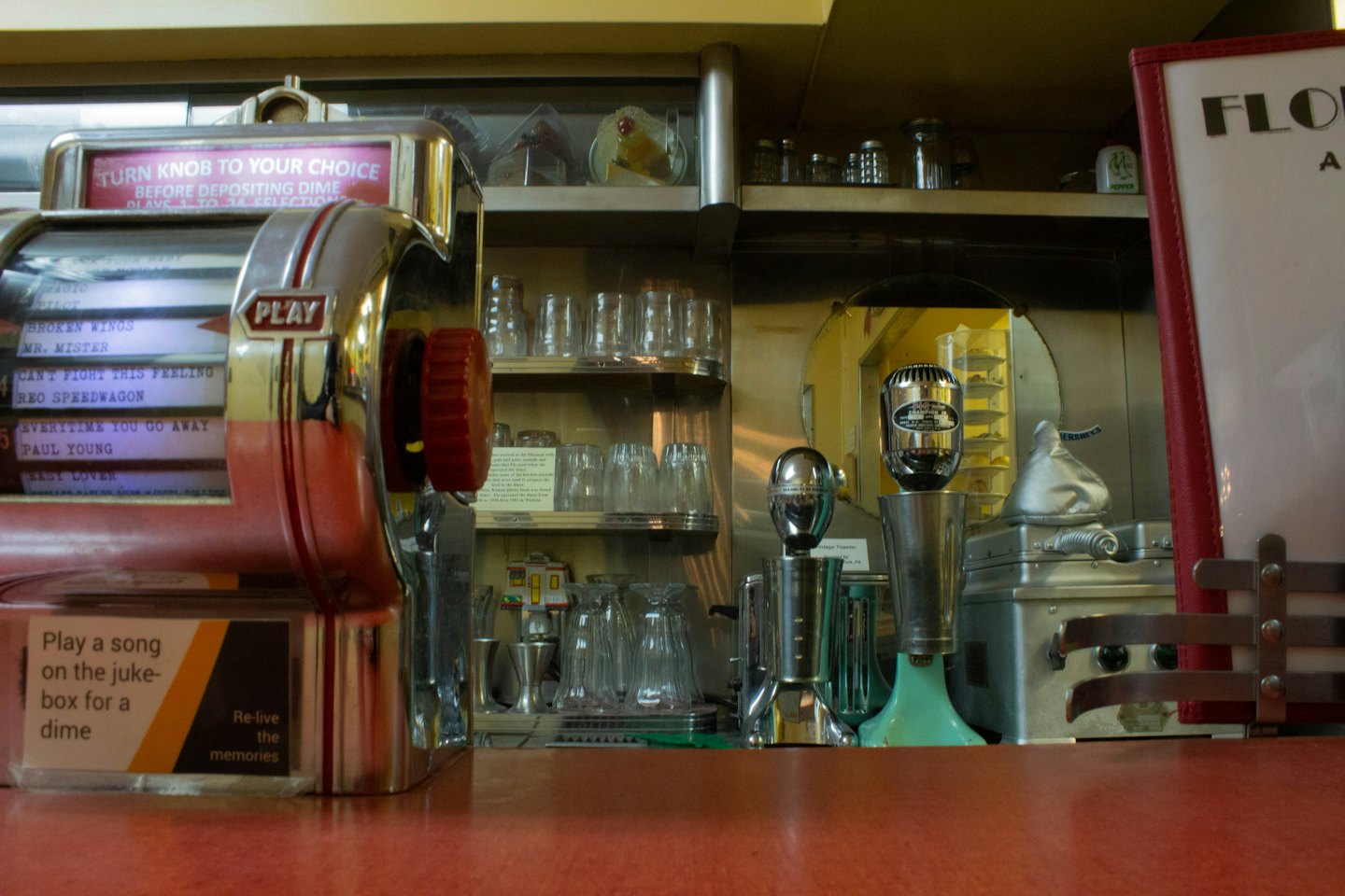 Ein Jukebox im Vintage-Stil steht auf einer Theke in einem Diner.