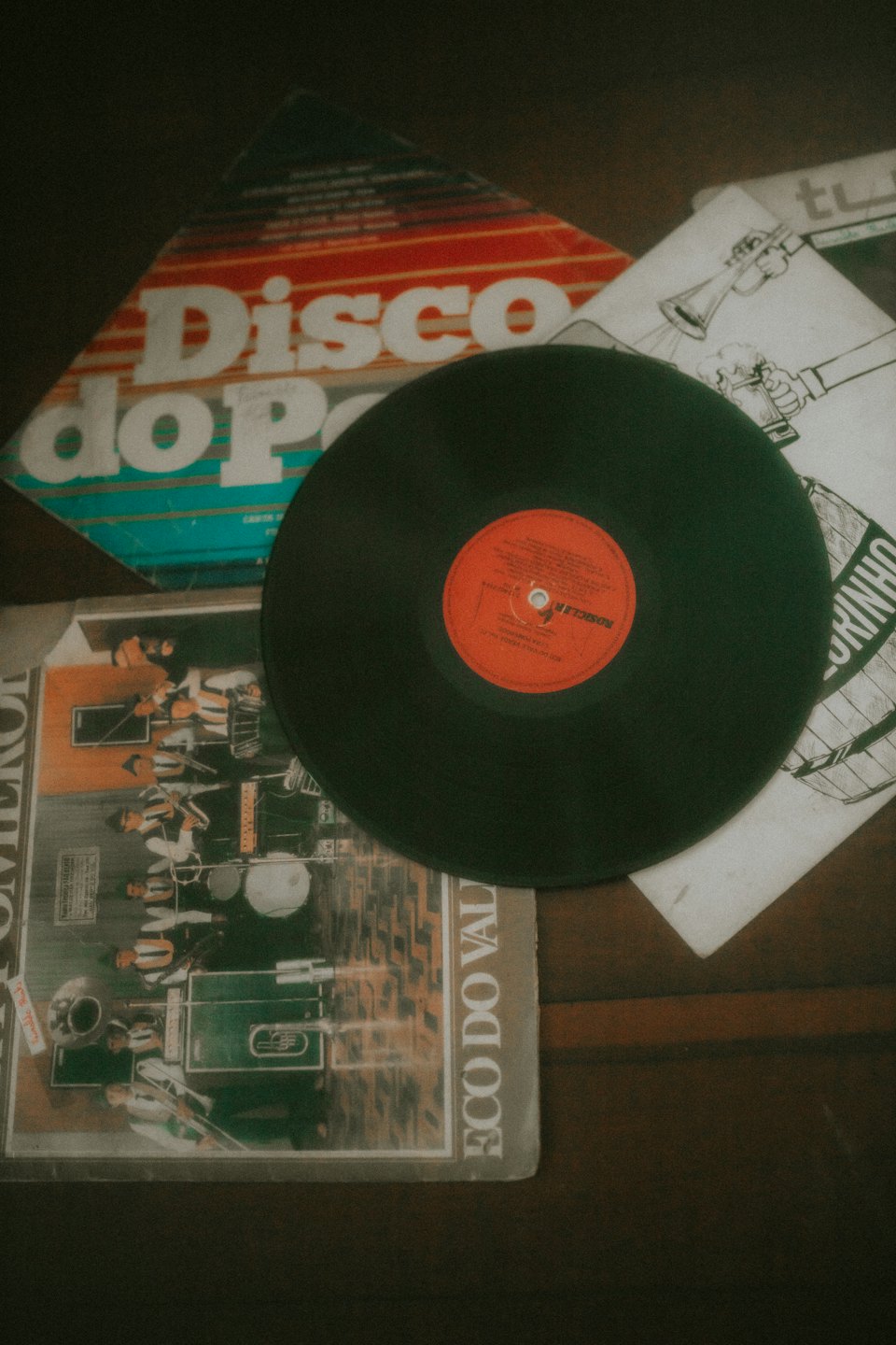 Alte Schallplatten und illustrierte Cover auf einem Tisch arrangiert.